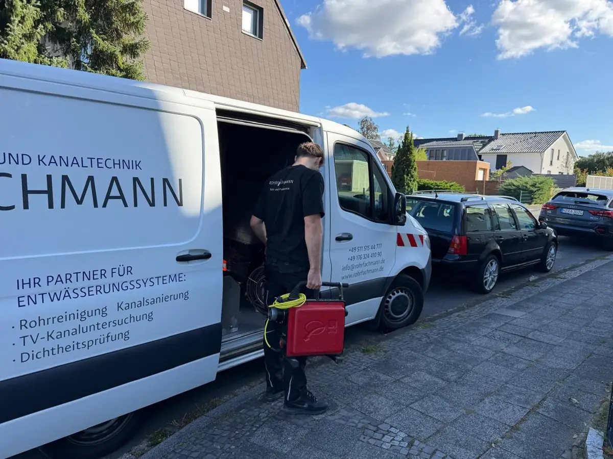 Techniker von Rohrfachmann mit Rohrreinigungsmaschine am Einsatzfahrzeug