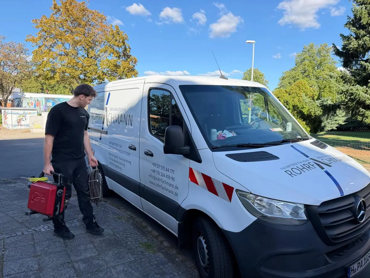 Rohrfachmann mit Rohrreinigungsmaschine auf dem Weg zum Einsatz